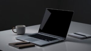 Closed laptop and notebook on a dark desk