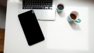 Smartphone and laptop on a pale desk
